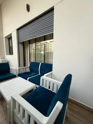 a group of blue chairs and a table on a balcony at Appartement 3 chambres avec piscine, proche de la plage Zenâta Eco City in Aïn Harrouda