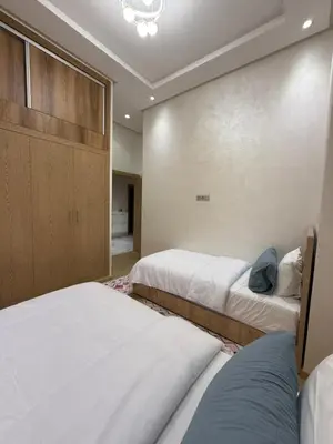 a bedroom with two beds and a closet at Appartement 3 chambres avec piscine, proche de la plage Zenâta Eco City in Aïn Harrouda