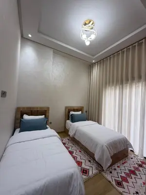 a bedroom with two beds and a window at Appartement 3 chambres avec piscine, proche de la plage Zenâta Eco City in Aïn Harrouda