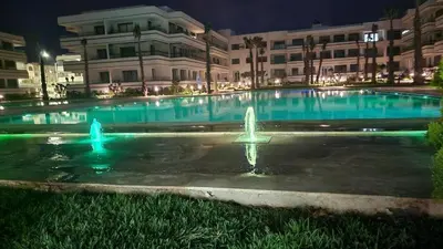 a large pool with a fountain in front of a building at Appartement à louer Eden Mansouria Residence in Mansouria