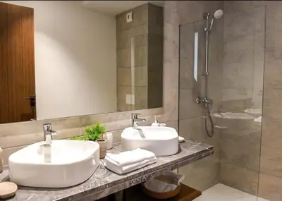 a bathroom with two sinks and a shower at Appartement Steps from Anfa Park Fanzone in Casablanca