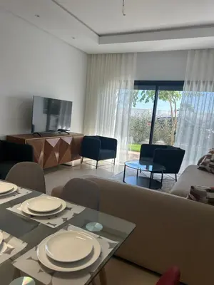 a living room with a couch and a table and chairs at Appartement Steps from Anfa Park Fanzone in Casablanca