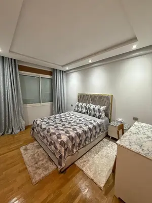 a bedroom with a bed and two rugs at Apartment luxurious a Hay Riad in Rabat