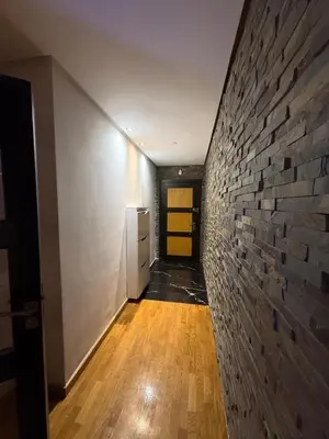 a hallway with a brick wall and a yellow door at Apartment luxurious a Hay Riad in Rabat