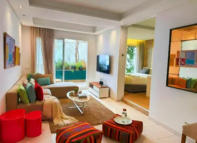 a living room with a couch and a tv at Maya Suites - Cozy Flat with Terrace & Garden in Casablanca