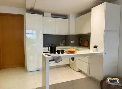 a kitchen with white cabinets and a counter top at Maya Suites - Cozy Flat with Terrace & Garden in Casablanca