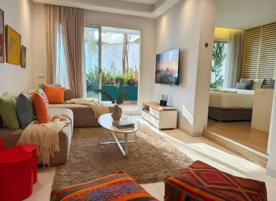 a living room with a couch and a bed at Maya Suites - Cozy Flat with Terrace & Garden in Casablanca