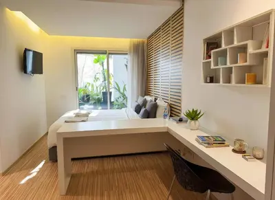 a bedroom with a bed with a desk and a window at Maya Suites - Cozy Flat with Terrace & Garden in Casablanca