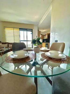 a living room with a glass table and chairs at Chic Cocoon & Impeccable Sea View in Zenata in Aïn Harrouda