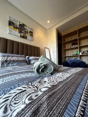 a bedroom with a large bed with a blue and white blanket at Chic Cocoon & Impeccable Sea View in Zenata in Aïn Harrouda