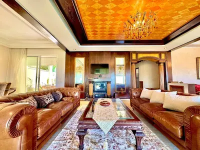 a living room with leather couches and a fireplace at Luxurious Ocean View Villa Ain Diab in Casablanca