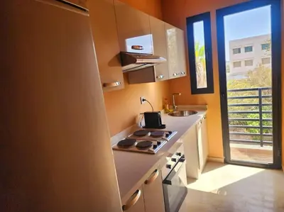 a kitchen with a stove and a sink and a window at Oasis de Sérénité avec Piscine in Casablanca