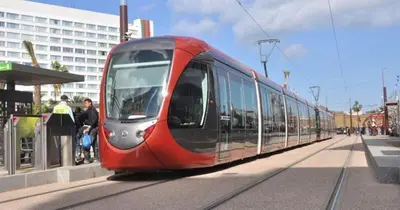 a red train on the tracks in a city at Cosy-Piscine-Parking in Casablanca