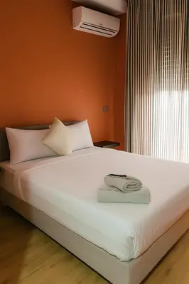 a bedroom with a bed with white sheets and a window at Cozy 2-bedroom studio in Casablanca