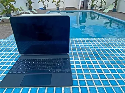 a laptop computer sitting on a table next to a swimming pool at Cozy 2-bedroom studio in Casablanca