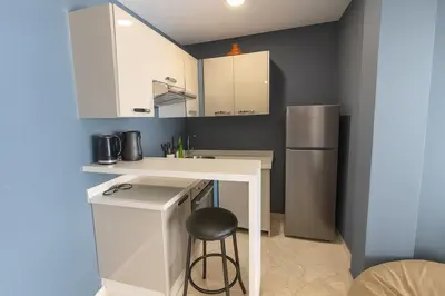 a small kitchen with a counter and a refrigerator at Cozy 2-bedroom studio in Casablanca