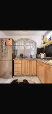 a kitchen with wooden cabinets and a stainless steel refrigerator at stay in villa casablanca in Casablanca