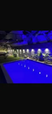 a large swimming pool with blue water at night at stay in villa casablanca in Casablanca