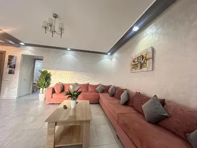 a living room with a red couch and a table at Marbella beach residency in Mansouria