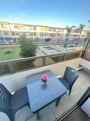 a balcony with a table and chairs and a tennis court at Marbella beach residency in Mansouria