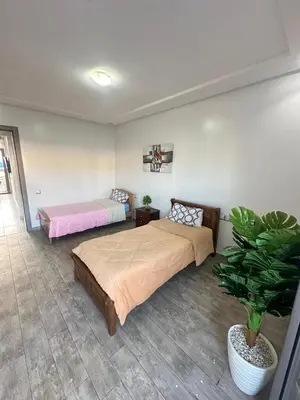 a bedroom with two beds and a potted plant at Marbella beach residency in Mansouria