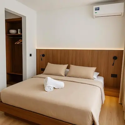a bedroom with a large bed with two towels on it at My Cosy Place Cosy Apartment Casa gare Oasis in LʼOasis
