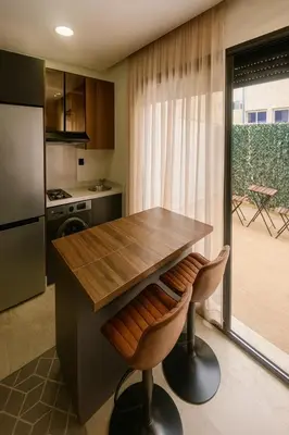 a kitchen with a wooden table and two stools at My Cosy Place Cosy Apartment Casa gare Oasis in LʼOasis