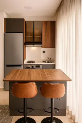 a kitchen with a wooden counter and two bar stools at My Cosy Place Cosy Apartment Casa gare Oasis in LʼOasis