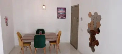 a dining room with a wooden table and chairs at Cosy studio dar bouazza in Casablanca