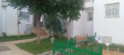 a green fence in front of a white building at Cosy studio dar bouazza in Casablanca