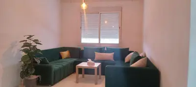 a living room with two green couches and a table at Cosy studio dar bouazza in Casablanca