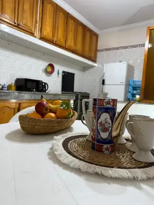 a kitchen counter with a bowl of fruit and a cup at family apartment in rabat in Rabat