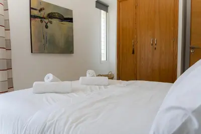 a white bed with two towels on top of it at Upper floor of a villa, Modern and bright in Rabat