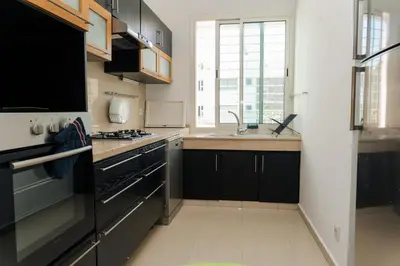 a kitchen with a sink and a stove top oven at Upper floor of a villa, Modern and bright in Rabat
