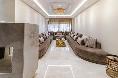 a living room with a large couch and a table at Large Comfort Duplex Casablanca Center in LʼOasis