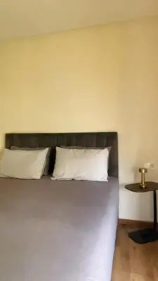 a bed with two white pillows and a table at Studio de standing à maarif in Maarif