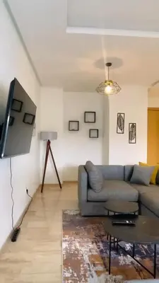 a living room with a couch and a tv at Studio de standing à maarif in Maarif