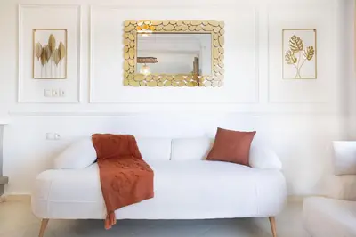 a white couch in a living room with a mirror at Sophia Atlantis Pool Patio Garage in Mohammedia