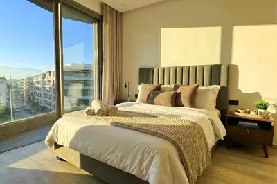 a bedroom with a large bed with a large window at Maya Suites - Mohamed V Stadium - Casablanca in Casablanca