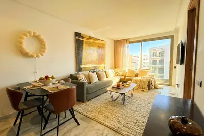 a living room with a couch and a table at Maya Suites - Mohamed V Stadium - Casablanca in Casablanca