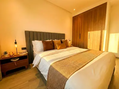 a bedroom with a large bed and a night stand at Maya Suites - Mohamed V Stadium - Casablanca in Casablanca