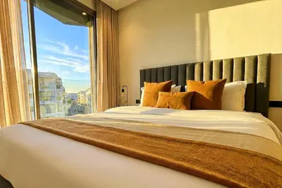 a bedroom with a large bed with a large window at Maya Suites - Mohamed V Stadium - Casablanca in Casablanca