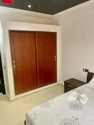 a bedroom with a bed and wooden cabinets at Le bon coin in Casablanca