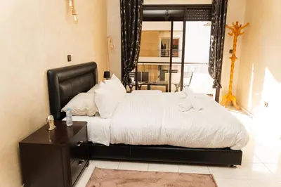 a bedroom with a large bed with a black headboard at Large 2 bedroom apartment in prime location - 2 Balconies & private Parking in Rabat