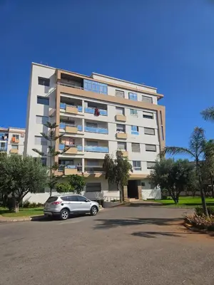 a car parked in front of a large building at Magnifique Appartement familial avec piscine in Mohammedia