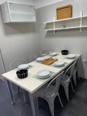 a white table with chairs and plates on it at Magnifique Appartement familial avec piscine in Mohammedia