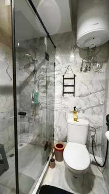 a bathroom with a toilet and a glass shower at Appartement Chaleureux à Bouznika- Plage Oued Cherrat - à 30min de Rabat 1chambre 2 salons in Sidi el Haj Bou Derbala