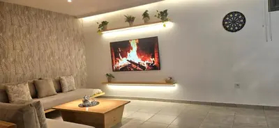 a living room with a couch and a fire on the wall at Green Nest, Loft with private garden-Free Parking- Fast WiFi- Netflix in Casablanca