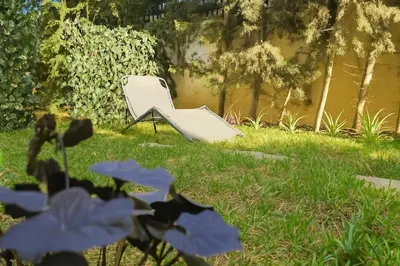 a white chair sitting in the grass in a yard at Green Nest, Loft with private garden-Free Parking- Fast WiFi- Netflix in Casablanca
