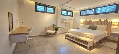 a bedroom with a bed and a desk and windows at Green Nest, Loft with private garden-Free Parking- Fast WiFi- Netflix in Casablanca